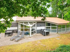 a house with a patio and a table and chairs at Holiday home Glesborg VI in Glesborg