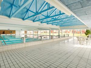 a swimming pool with tables and chairs in a building at Holiday home Lemvig XLIV in Lemvig