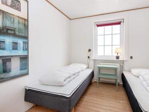 2 camas en una habitación con ventana y mesa en Holiday home Thyborøn VI, en Thyborøn