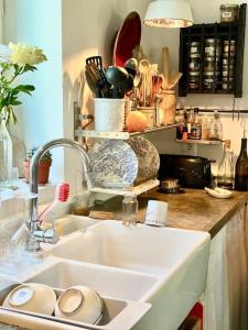 eine Küche mit einer Spüle und einer Theke mit Geschirr in der Unterkunft Charming Romantic Tower in Chateau Estate in Ocquerre