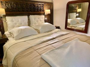 ein großes Bett in einem Schlafzimmer mit einem großen Spiegel in der Unterkunft Charming Romantic Tower in Chateau Estate in Ocquerre + 62 Fotos