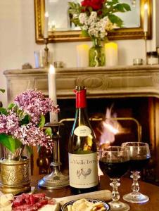 eine Flasche Wein auf einem Tisch mit Gläsern Wein in der Unterkunft Charming Romantic Tower in Chateau Estate in Ocquerre