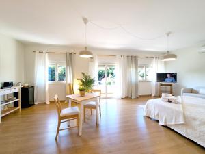 a living room with a bed and a table and chairs at Villa Prana Guesthouse, Yoga & Ayurveda in Portimão