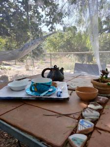 uma mesa com um bule de chá e tigelas sobre ele em CASA Adriana Affascinante casa in pietra em Buseto Palizzolo
