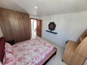Schlafzimmer mit einem Bett und einem Wandspiegel in der Unterkunft Apparts MT in Sousse