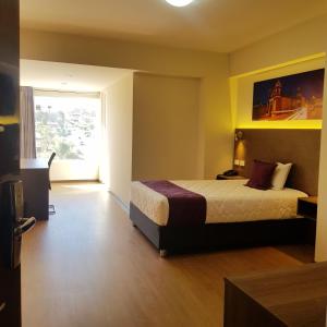 um quarto de hotel com uma cama e uma janela em Valle Sur Hotel Moquegua em Moquegua
