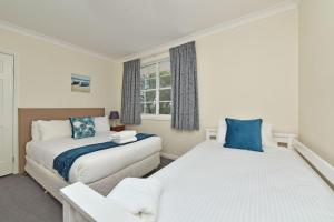 a bedroom with two beds and a window at Beggars Bridge Vineyard Homestead with pool and tennis in Rothbury +36 photos