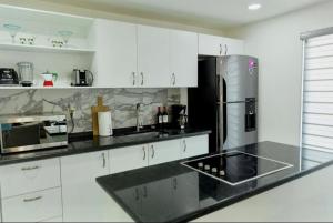a kitchen with white cabinets and a stainless steel refrigerator at Presidential Suite in Cabo San Lucas