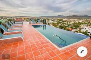 a large swimming pool on top of a building at Presidential Suite in Cabo San Lucas