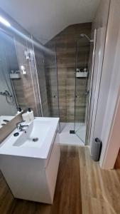 een badkamer met een witte wastafel en een douche bij Casa dos Albardeiros in Moura