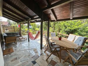 a patio with a table and chairs and a hammock at Kuća za odmor PIKA - Mrežnica in Duga Resa