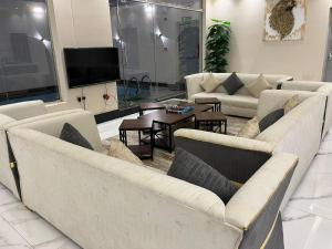 ein Wohnzimmer mit 2 Sofas und einem TV in der Unterkunft فلل اسوار الوسام لبيوت العطلات in Ta'if