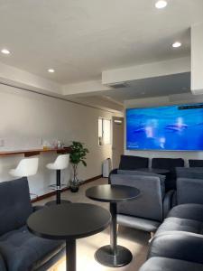 uma sala de estar com sofás e uma televisão de ecrã grande em 2023 NEW OPEN Island Japan Hotel & Cafe em Tóquio