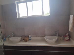 a bathroom with two sinks sitting under a window at CASA CAMPESTRE COMPLETa in Barbosa