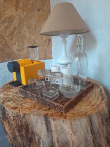 una mesa con lámpara, vasos y una botella en Páteo das Laranjeiras, en Tomar