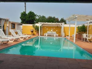 een zwembad met stoelen en een tafel en een patio bij Páteo das Laranjeiras in Tomar