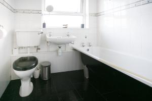 a bathroom with a toilet and a sink and a tub at So-Cute Cityside in Belfast