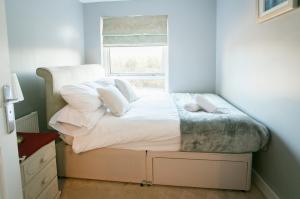 een bed met kussens en een raam in een kamer bij So-Cute Cityside in Belfast +5 foto's