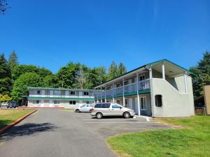 un edificio con dos coches estacionados en un estacionamiento en Stellar Motel, en Port Orchard