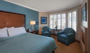 una camera d'albergo con un letto e due sedie di Blue Dolphin Inn a Cambria