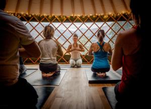 - un groupe de personnes assises dans une yourte faisant du yoga dans l'établissement Kinloch Wilderness Retreat, à Glenorchy