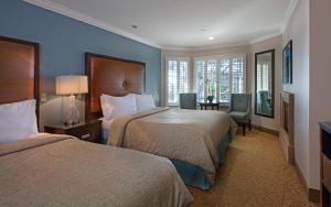 a hotel room with two beds and a desk at Blue Dolphin Inn in Cambria