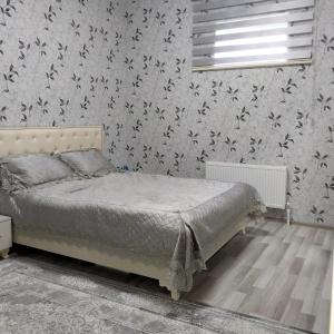 1 dormitorio con cama y pared cubierta de mariposas en Qebele Resot home en Gabala