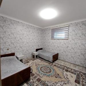 1 dormitorio con 2 camas y alfombra en Qebele Resot home en Gabala