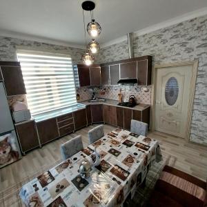 a kitchen with a table and chairs in a room at Qebele Resot home in Gabala