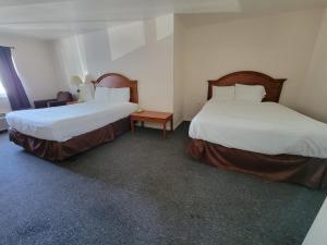 Habitación con 2 camas y mesa. en Stellar Motel, en Port Orchard