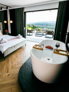 baño con bañera y cama y vistas en Evo Residence Panoramic, en Cluj-Napoca