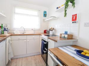 a kitchen with white cabinets and a sink at Dolly's Lookout in Lowestoft