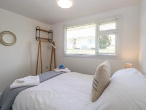 a bedroom with a white bed and a window at Dolly's Lookout in Lowestoft