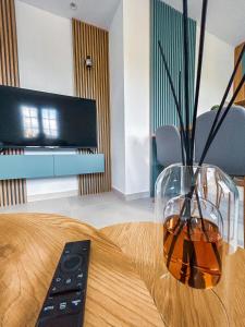 a vase sitting on a table with a remote control at Sunset Apartment in Kotor