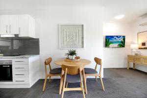 a kitchen and dining room with a table and chairs at Ocean Spray 7 in Coffs Harbour