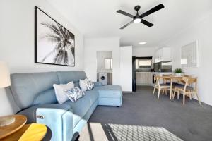 a living room with a blue couch and a table at Ocean Spray 7 in Coffs Harbour