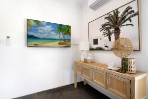 a living room with a dresser and a painting on the wall at Ocean Spray 7 in Coffs Harbour