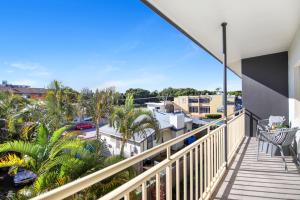 a balcony with a view of palm trees and buildings at Ocean Spray 7 in Coffs Harbour