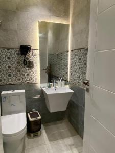 uma casa de banho com um lavatório, um WC e um espelho. em فلل اسوار الوسام لبيوت العطلات em Taif