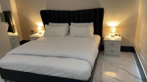 1 dormitorio con 1 cama grande y 2 mesitas de noche en فلل اسوار الوسام لبيوت العطلات, en Taif