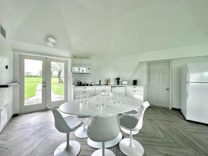 a white kitchen with a white table and chairs at Sumner Lake Tiny House in Clermont