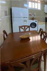 una mesa de madera con sillas y un bol encima en Grand appartement 1 chambre en Tánger