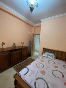 1 dormitorio con cama y lámpara de araña en Grand appartement 1 chambre en Tánger