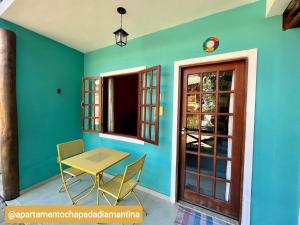 a table and chairs in a room with a blue wall at Apartamento Chapada Diamantina in Lençóis