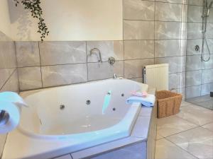 uma banheira branca na casa de banho com um lavatório em Arthurs Holiday Villa em Arthurs Seat