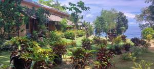 Bohol-Lahoy Dive Resort في Guindulman: منزل به نباتات أمام المحيط