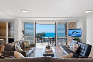 uma sala de estar com um sofá e vista para o oceano em Spectacular Location and Views, 3 Bedrooms , Private Rooftop Spa em Mooloolaba