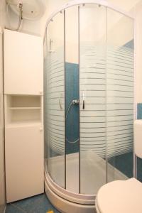 La salle de bains est pourvue d'une douche en verre et de toilettes. dans l'établissement Apartments by the sea Opatija - Volosko, Opatija - 7846, à Volosko