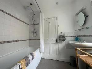een badkamer met een ligbad en een wastafel bij Lookout Cottage in Penzance +20 foto's