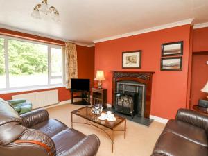 a living room with a couch and a fireplace at Britannia Cottage in Llanrhystyd
